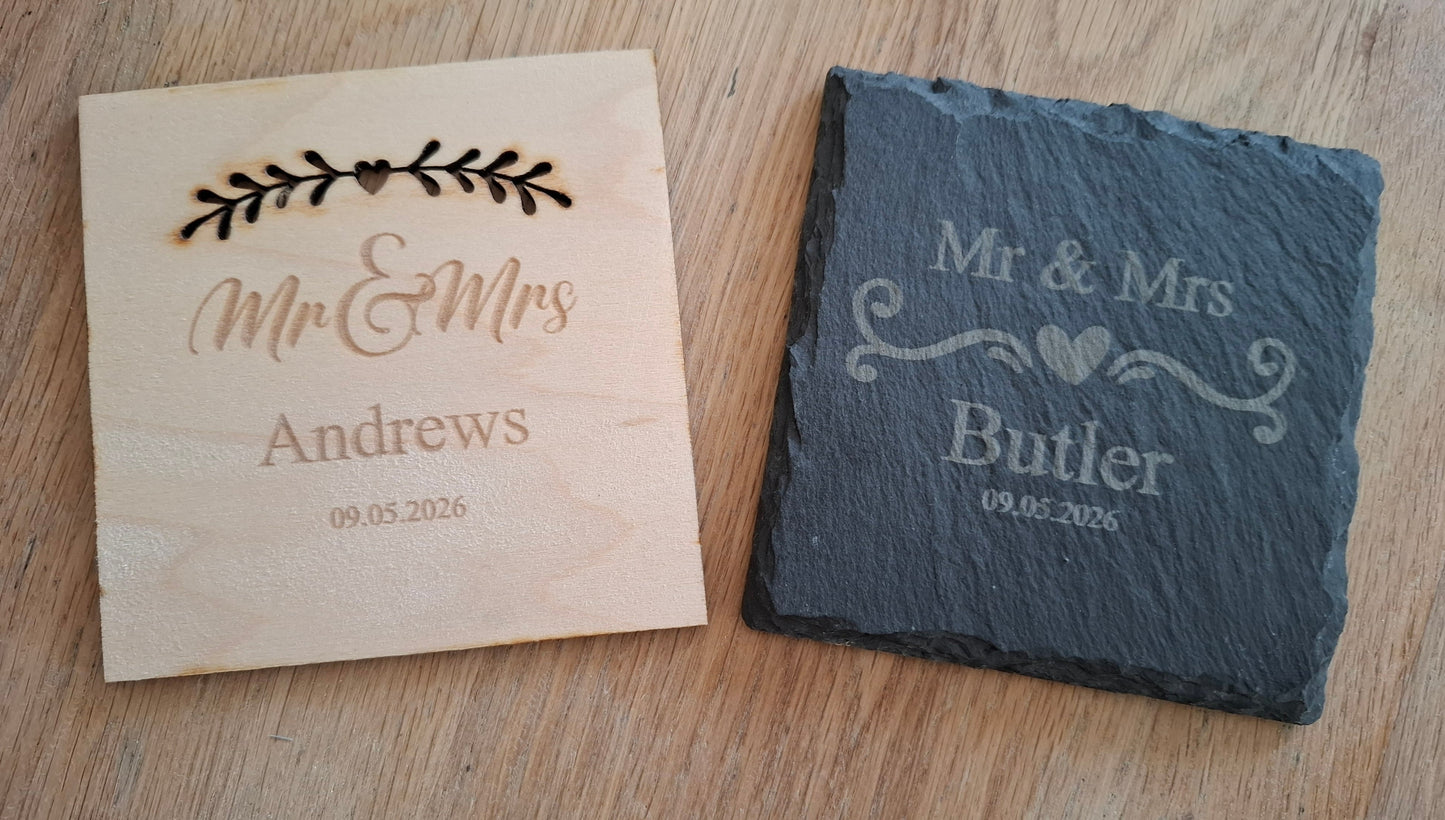Wooden and slate coasters with engraved 'Mr & Mrs' names on a wooden surface